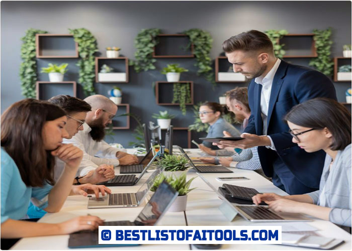 a group of people sitting around a table with laptops